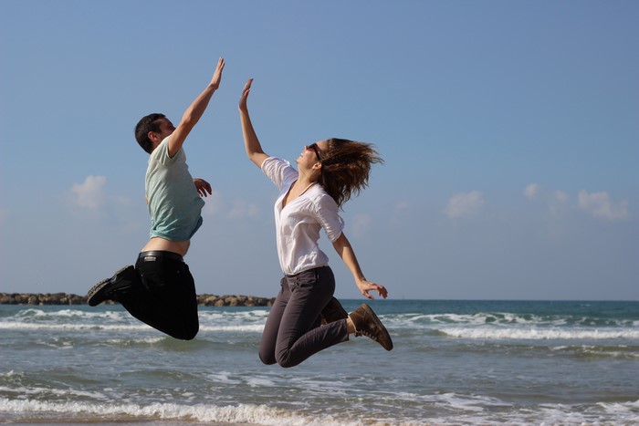 Two people jumping on a beach
