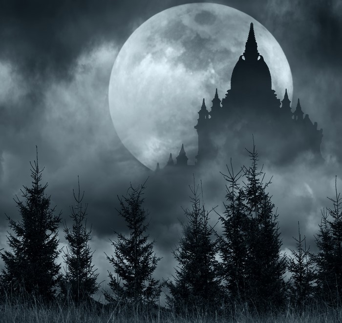 Temples silhouetted against a full moon at night