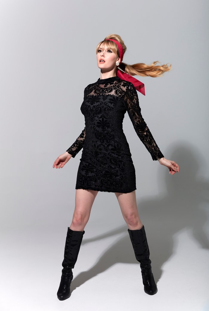 Carla Monaco wearing a black dress and boots