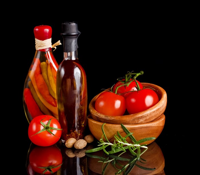 Bottles of Peppers and Oil with Tomatoes and Rosemary