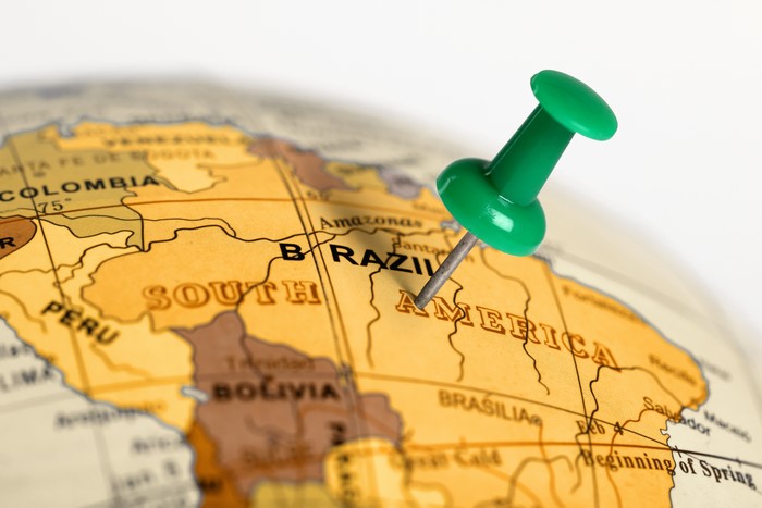 Green pushpin on Brazil on a globe