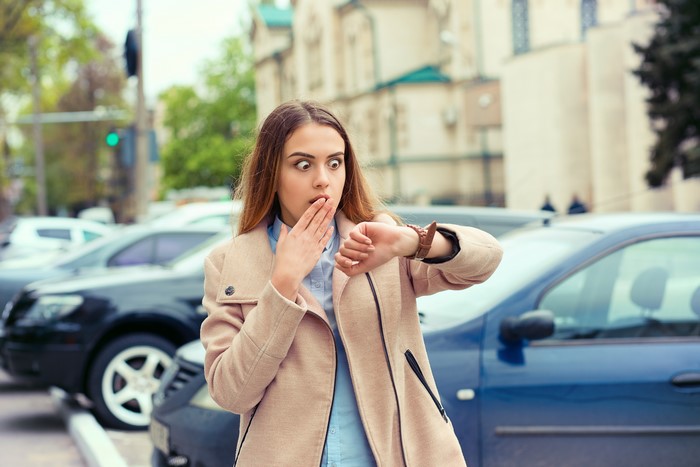 Woman checking watch with surprise
