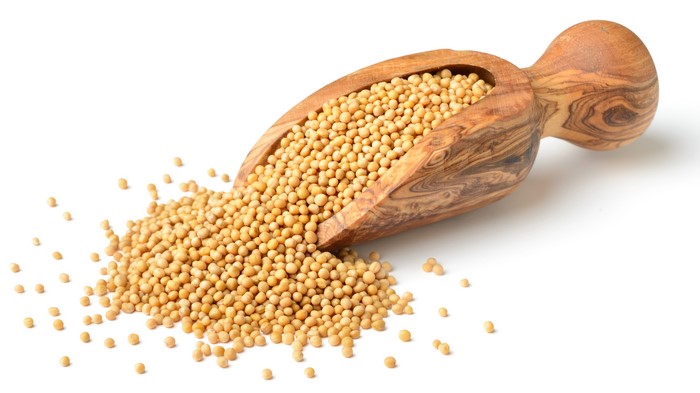 Mustard seeds in a wooden scoop