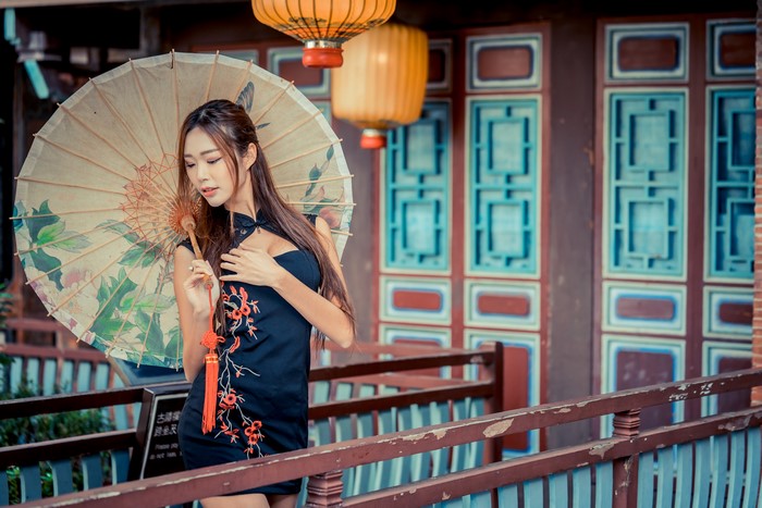 Asian woman in dress holding umbrella
