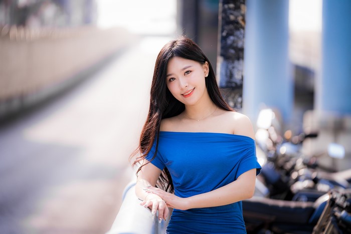 Asian woman in blue off-the-shoulder dress