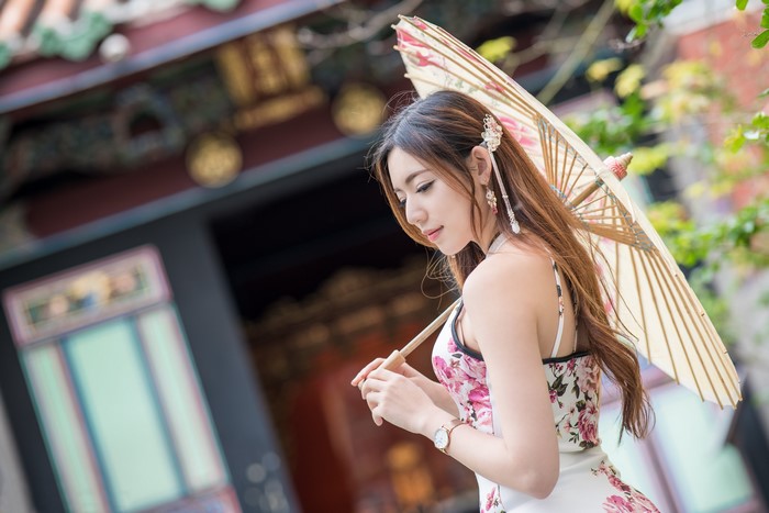 Asian woman with umbrella in traditional setting