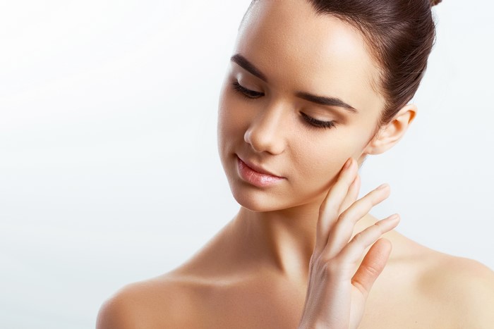 Brown haired woman with hand on face