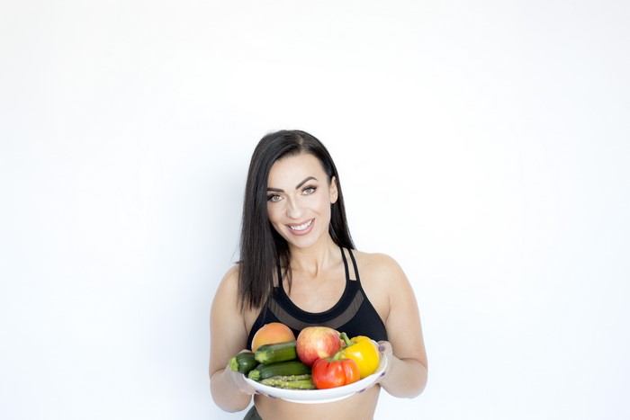 Woman holding a tray of fruits and vegetables