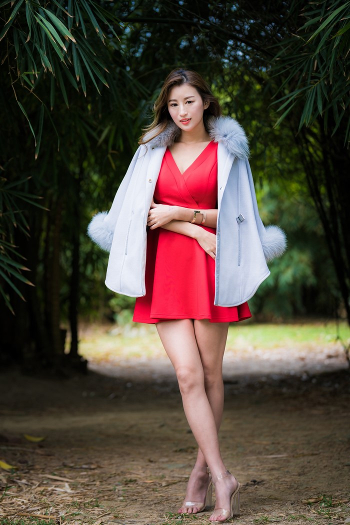 Asian woman in red dress and fur-trimmed coat