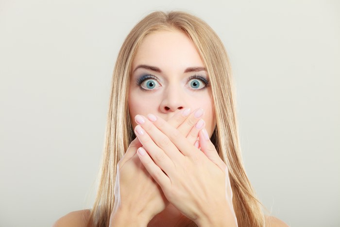 Woman covering mouth with hands