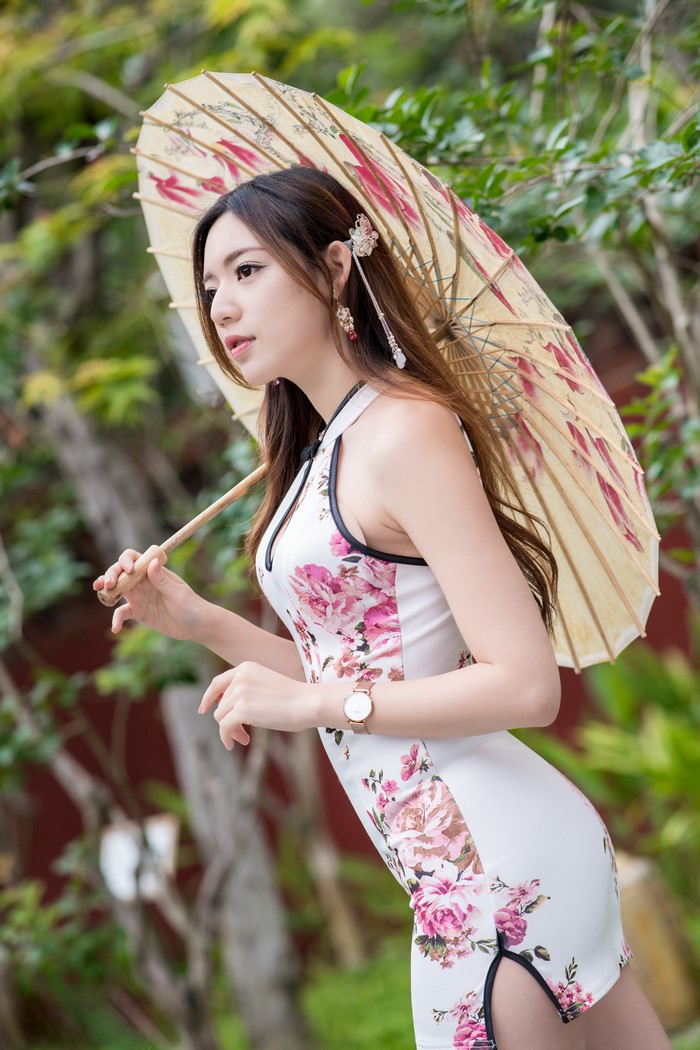 Woman in floral dress holding an umbrella