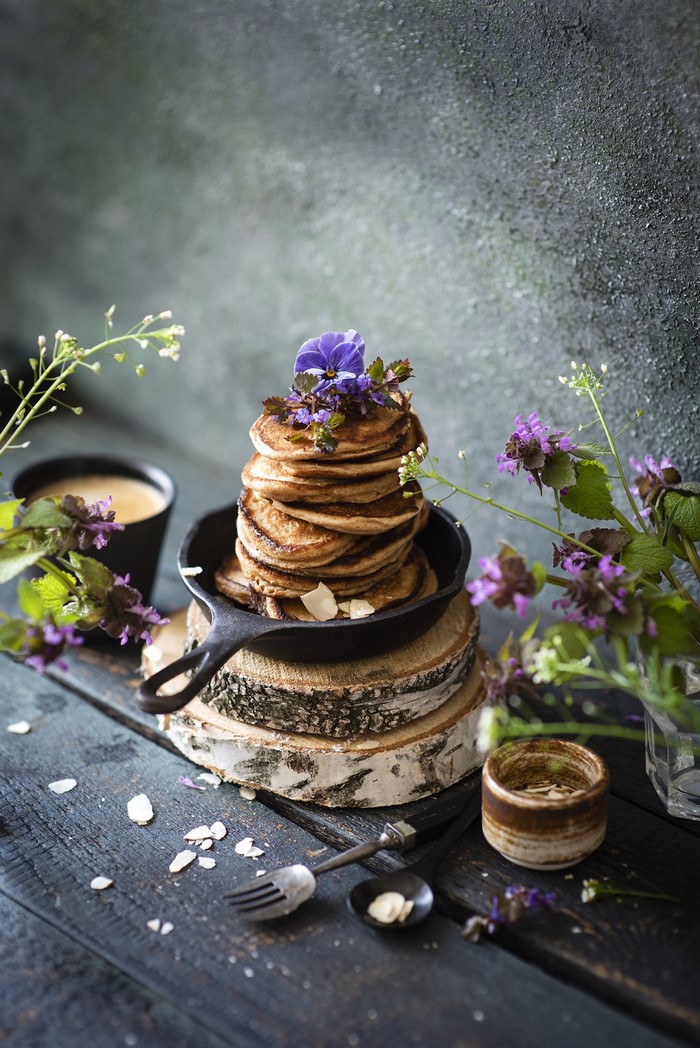 Stack of pancakes in a cast iron pan with flowers