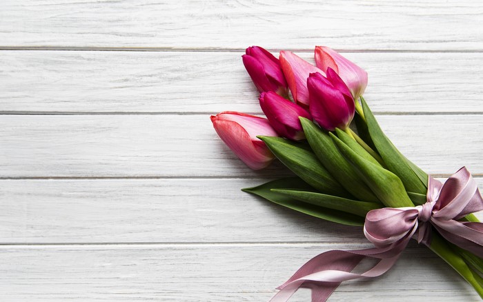 Bouquet of pink and purple tulips on wood planks