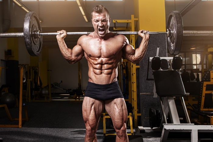 Bodybuilder lifting a barbell in a gym
