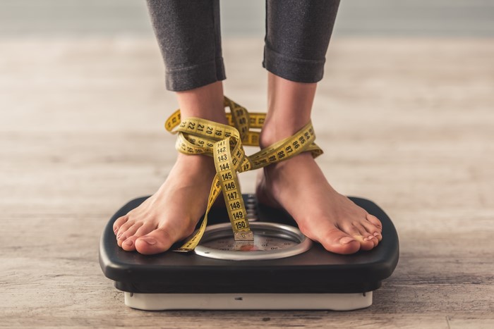 Legs on a scale with a tape measure
