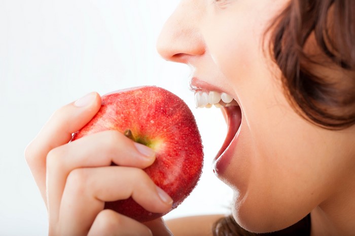 Woman eating a red apple