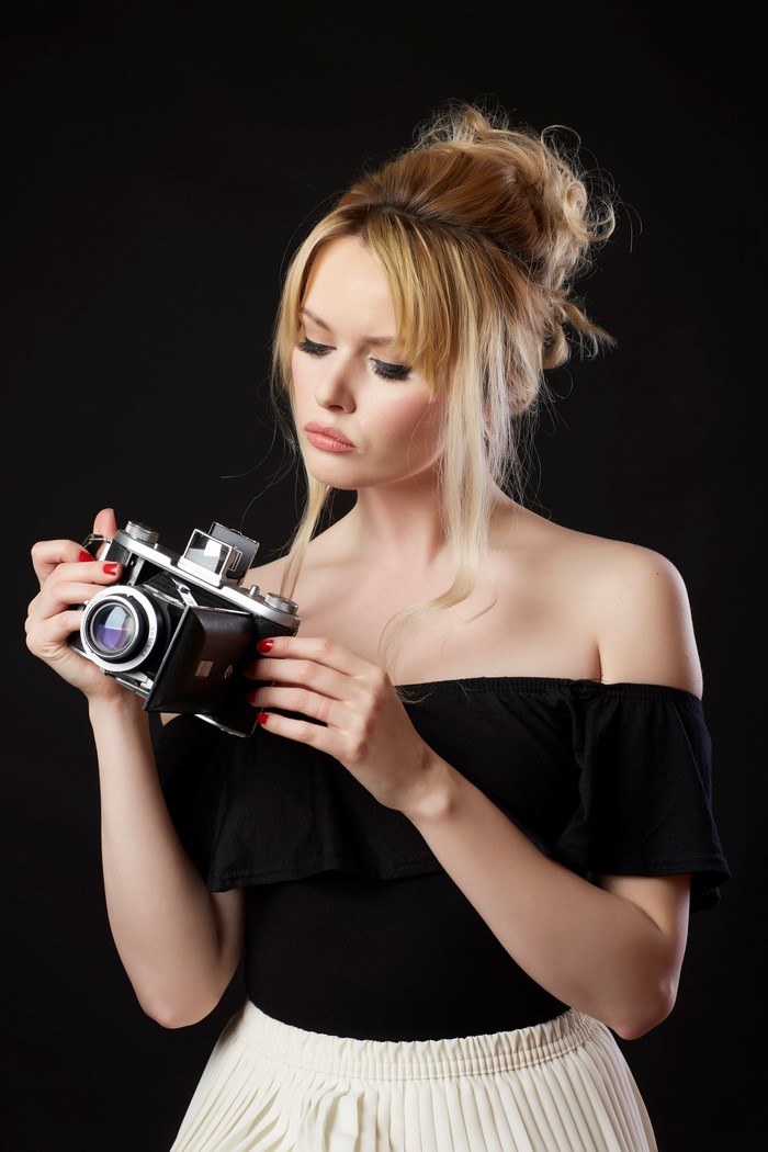 Blonde woman holding a vintage camera
