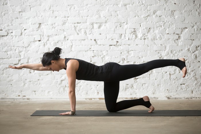 Woman performing yoga pose on mat