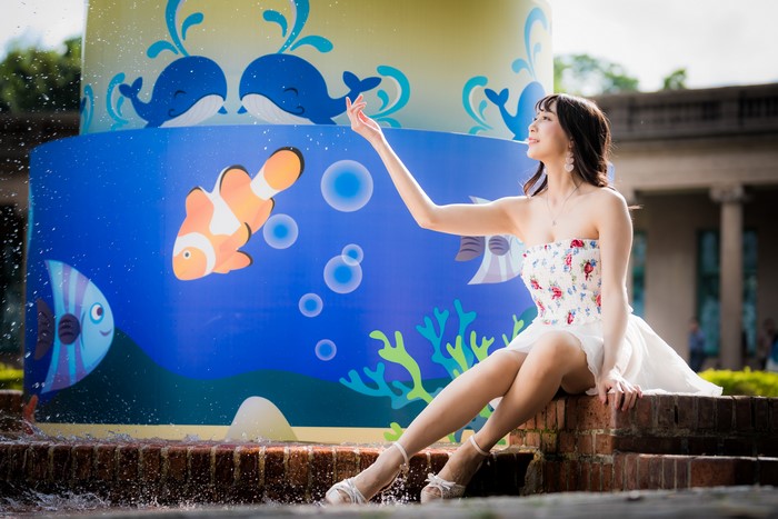 Asian Woman Sitting by Underwater Mural