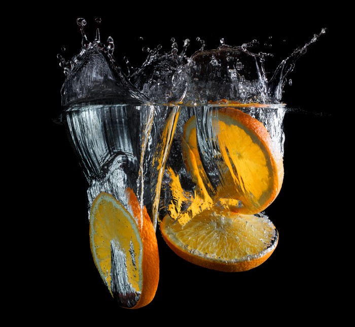 Orange slices splashing into water