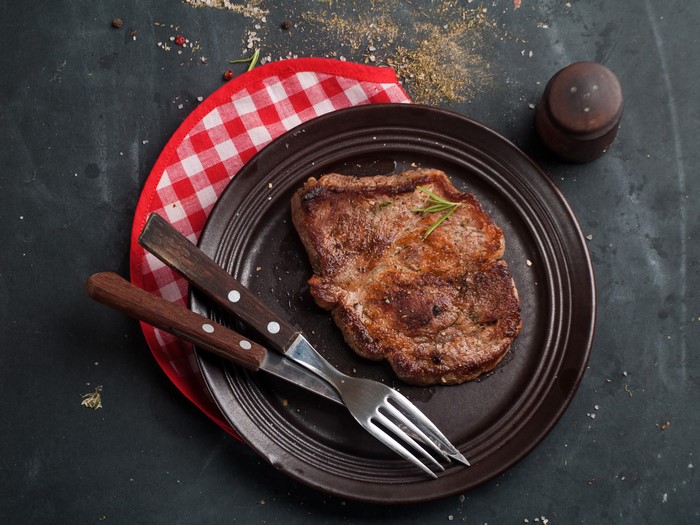 Cooked steak on a plate with cutlery