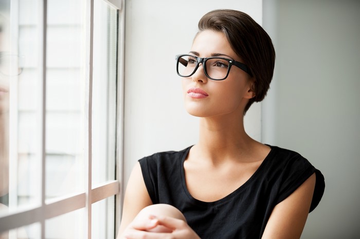 Woman with short hair and glasses by the window