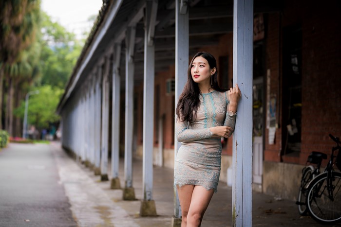 Asian woman in a dress standing by pillars