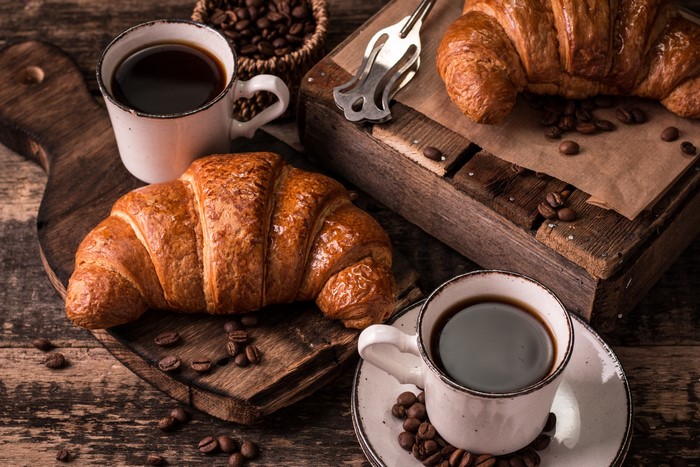 Two Croissants and Coffee on Wooden Surface