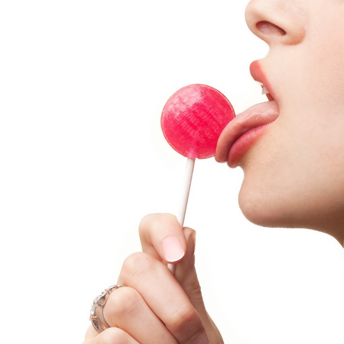 Woman licking a red lollipop