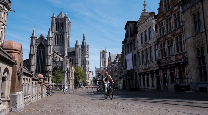 Ghent, Belgium street with cyclist and cathedral