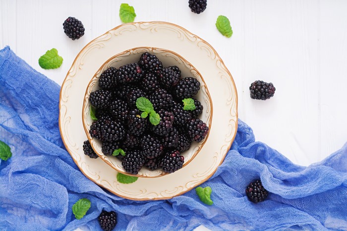 Blackberries on a plate with mint leaves