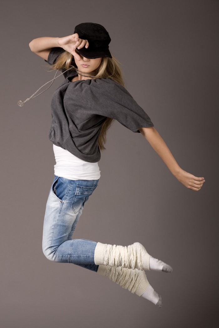 Girl in baseball cap jumping in jeans