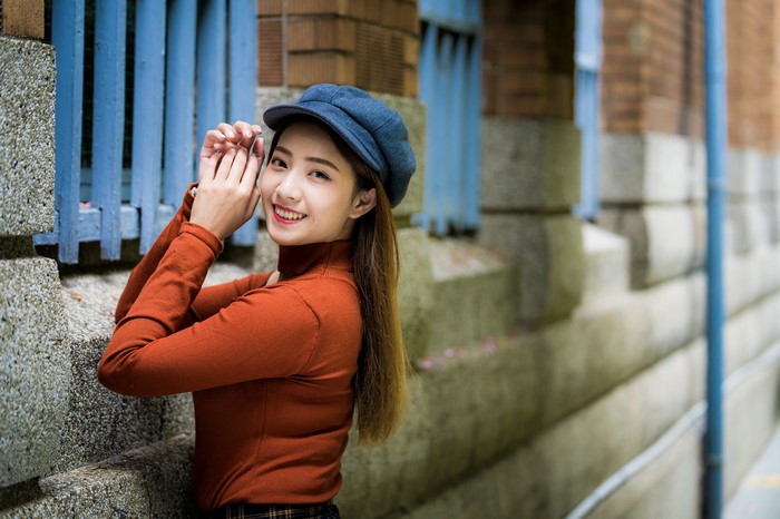 Asian woman wearing a baseball cap and turtleneck
