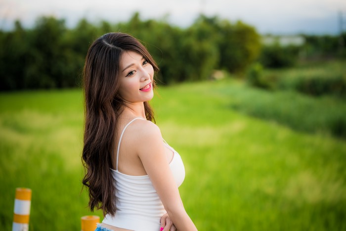 Asian woman in white singlet outdoors