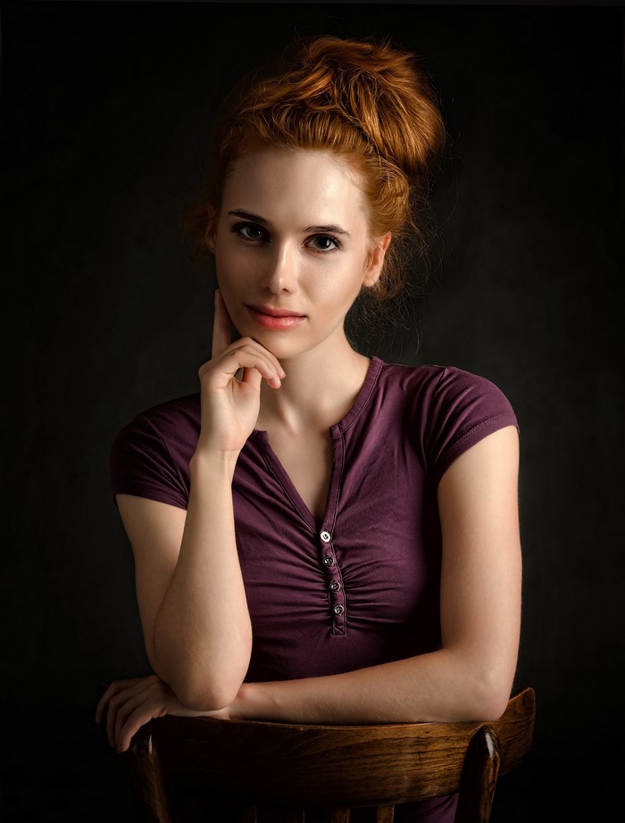 Redhead girl with hand on chin