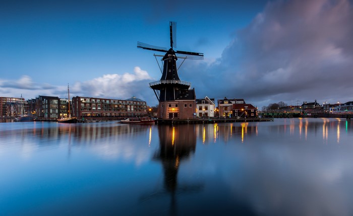 Windmill and buildings on a canal in Haarlem, Netherlands at dusk