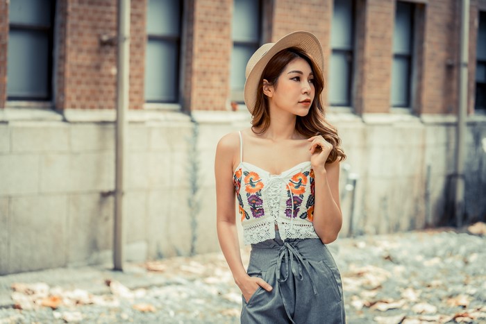 Asian woman wearing a hat and floral singlet