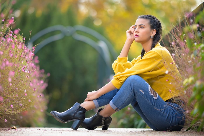 Woman with braid hair sitting in a park