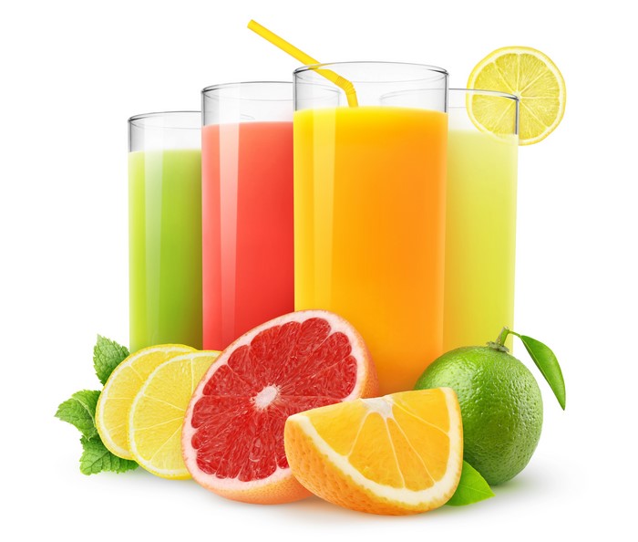 Four glasses of citrus juice with fruits