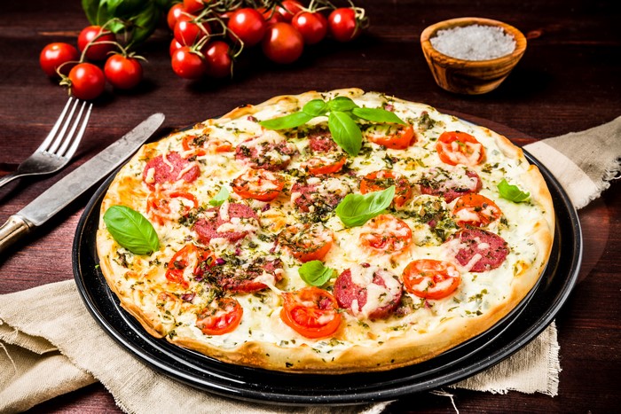 Pizza with Tomatoes, Basil, and Salami on a Plate