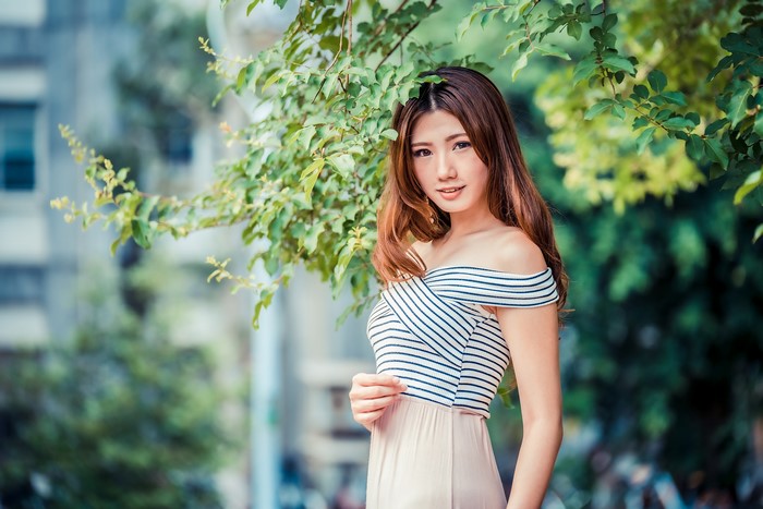 Asian woman with brown hair under branches