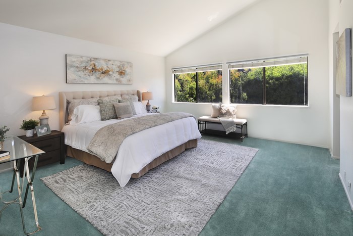 Bedroom with bed, lamps, and carpet