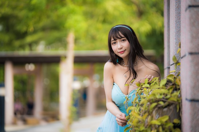 Brunette girl in a blue dress with décolletage