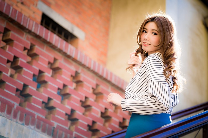 Asian woman with brown hair in striped blouse