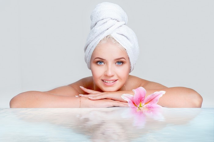 Woman with towel and flower in spa