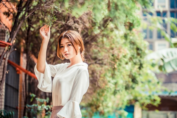 4K Asian Woman Among Green Branches