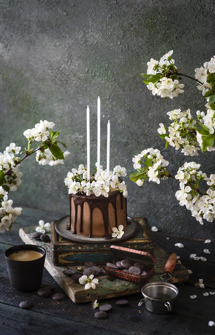 Chocolate cake with white flowers and candles