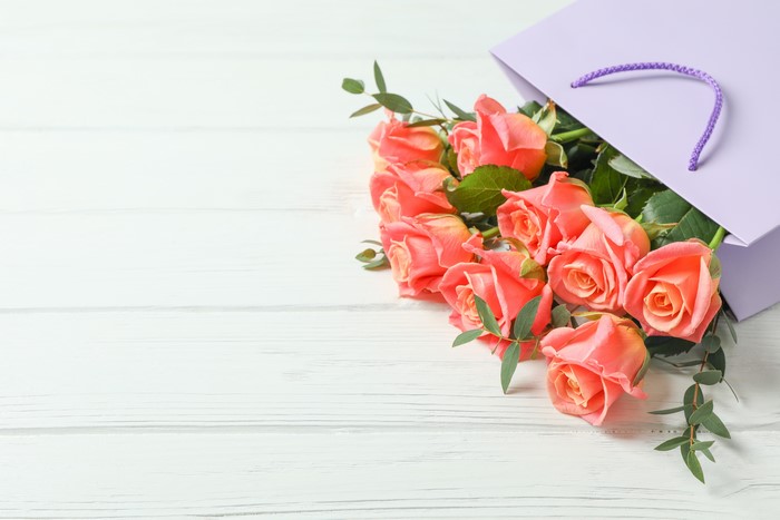 Pink Roses in a Purple Gift Bag on Wood Planks