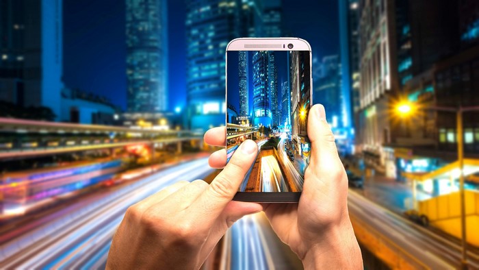 Smartphone capturing city lights at night