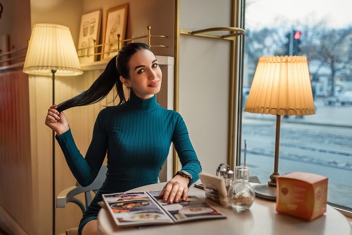 Brunette girl sitting at a table in a cafe
